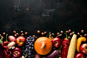 Different seasonal autumn vegetables and fruits on green wooden background