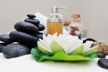 Obraz na płótnie Canvas stones for massage , massage oil and a flower in Spa salon.Stone therapy