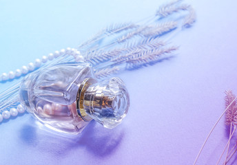 стеклянный флакон с духами на светлом фоне 