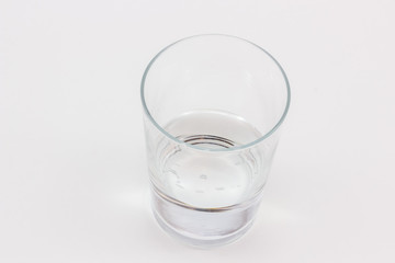 A glass with a little water in it.