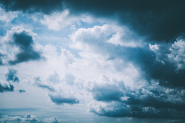 Fototapeta Dunkle Wolken bei blauem Himmel und Sonnenschein mit dramatischer Atmosphäre fotografiert obraz
