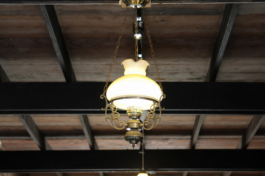 Antique lamp hanging on wooden ceiling.