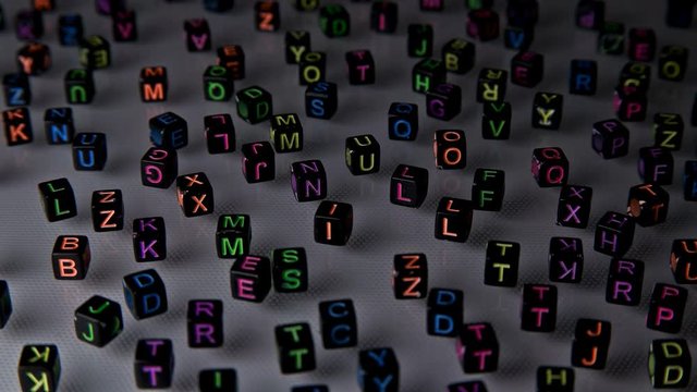 black blocks with colored letters scattered on a white background