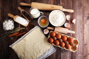 Bakery ingredients - flour, eggs, butter, sugar, yolk, almond nuts on blue table. Sweet pastry baking concept.