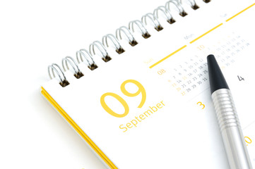 Desk calendar and pen on white background