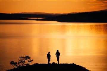 Two men sunrise on lake Baikal landscape
