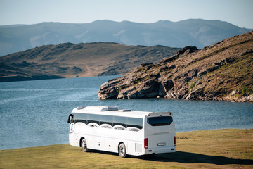 white tourist bus goes to the lake