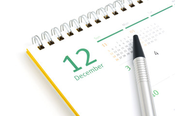 Desk calendar and pen on white background