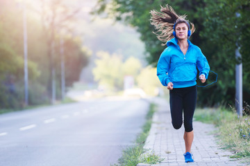 Urban woman jogger running by the road