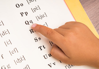 The child is studying the alphabet.