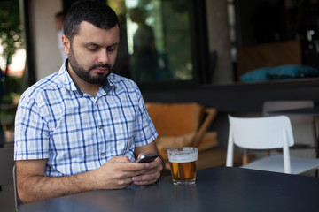 Fototapeta na wymiar Bearded man using mobile phone in bar