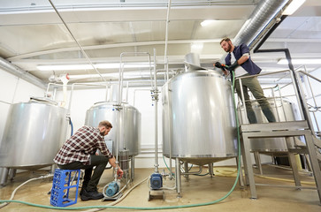 men working at craft beer brewery kettles