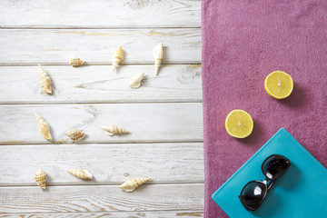 Bearch towel, sunglasses and summer accessories on white wooden background. Travel concept. View from above. Blank mock up for advertising or packaging.