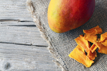 Raw organic dried mango and fresh ripe mango fruit on wooden rustic table.Dried mangos.Selective...
