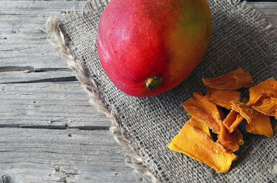 Raw organic dried mango and fresh ripe mango fruit on wooden rustic table.Dried mangos.Selective focus.