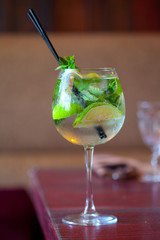 Glass tank mojito at the bar closeup. refreshing drink with Fresh mint, limes, sugar