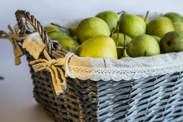 Green pears in a wicker basket