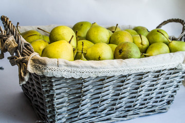 Green pears in a wicker basket