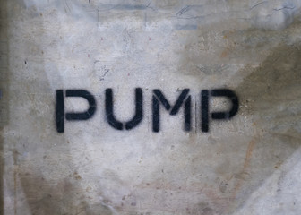 Text "PUMP" by spraying on the cement wall.