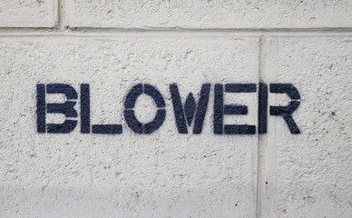 Text "BLOWER" by spraying on the cement wall.
