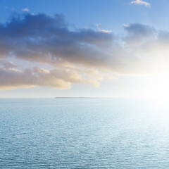 aerial view to blue sea and sunset in clouds over it