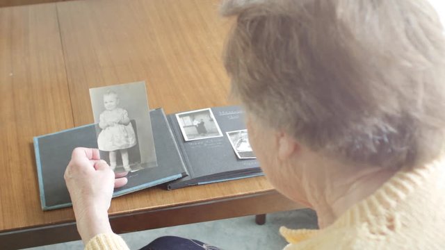 Senior woman looking through old photograph album