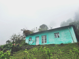 Fototapeta na wymiar Lonely Turquoise House in White Mountain Fog.