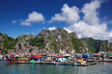 traditional vietnamese boats and floating village among beautiful limestone rocks of Lan Ha bay,...