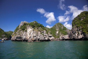Naklejka premium boats among beautiful limestone rocks of Lan Ha bay, the twin of Ha Long bay ona sunny day, Vietnam