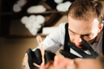 Master cuts hair and beard of men in the barbershop