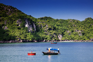 Naklejka na ściany i meble boats among beautiful limestone rocks of Lan Ha bay, the twin of Ha Long bay ona sunny day, Vietnam