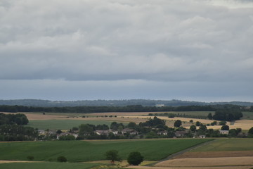 Obraz premium Le village de Fontaine au Périgord Vert ,au milieu des champs sous un ciel gris au crépuscule