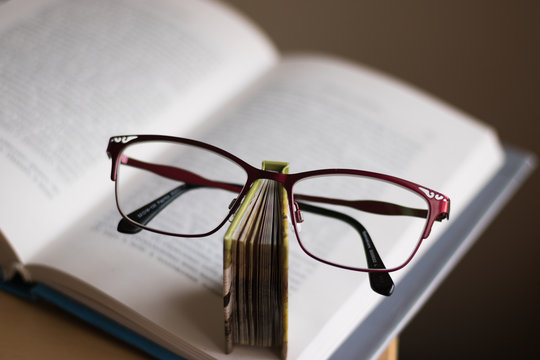 Close-up image of simple teacher's things: books and glasses. Concept: greeting card for Teacher's Day.