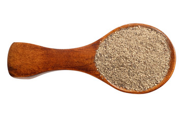 Ground black pepper in a wooden spoon