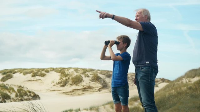 Grandchild exploring beautyful surrounding with granfather