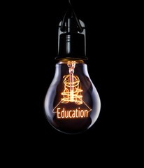 Hanging lightbulb with glowing Education concept.