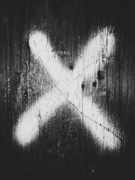 The letter X spray painted on telephone pole. close up