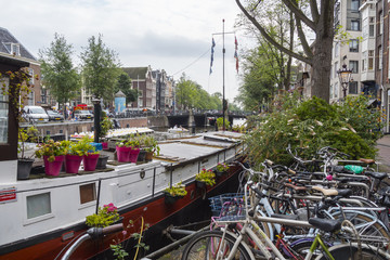 Fototapeta na wymiar Beautiful House Boats in the canals of Amsterdam - AMSTERDAM - THE NETHERLANDS - JULY 20, 2017