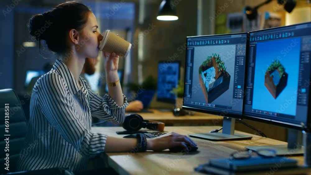 Poster female game developer works on a level design on her personal computer with two displays, she works 