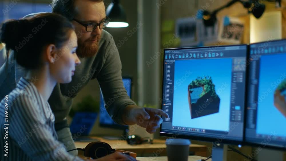 Poster Female Game Developer Has Discussion with Male Project Manager While Working on a Game Level on Her Personal Computer with Two Displays. They Work in a Modern Loft Office Creative Environment. 