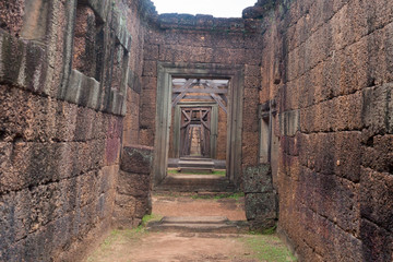 Corridor of Stone Walls and Ancient Trees close to a Wood Door in Siem Reap Angkor Wat Temple Cambodia Asia Tomb Raider