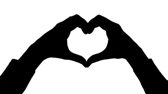 Moving male hands heart gesture/hand heart Black silhouette of two male hands holding fingers in a heart shape appears moving from the bottom of the frame against white background