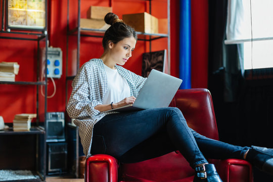 Businesswoman working on laptop in a creative office.