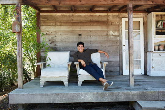 Portrait of mature Hispanic man in front of farmhouse cottage