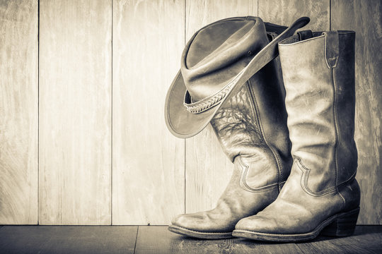 Wild West Retro Leather Cowboy Hat And Old Boots. Vintage Style Sepia Photo