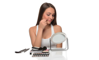 beautiful young female checking her facde skin