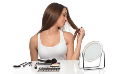 Young woman combing her hair, isolated on white background