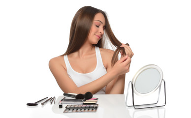 Young woman combing her hair, isolated on white background