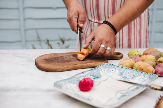 A man demonstrating the correct way to peel Prickly pear fruits to avoid the thorns