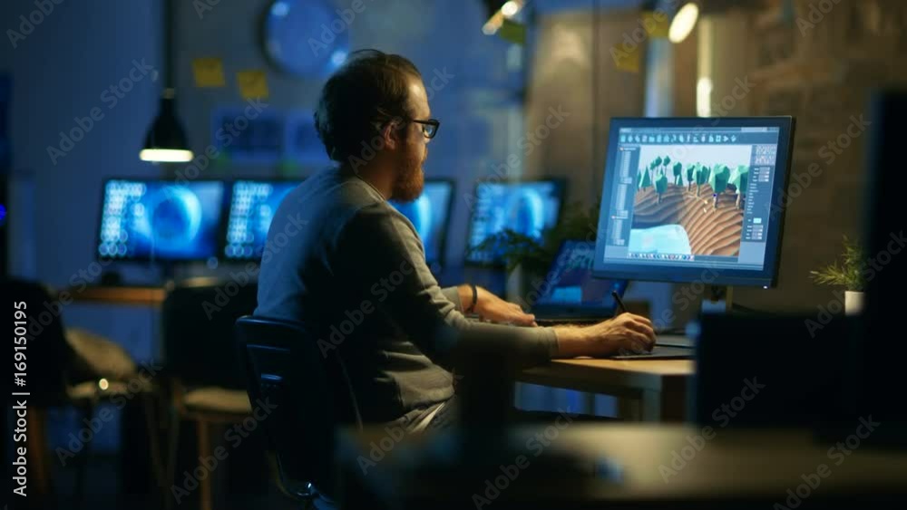 Poster male game developer works with graphic tablet, he creates new game level on his personal computer. h